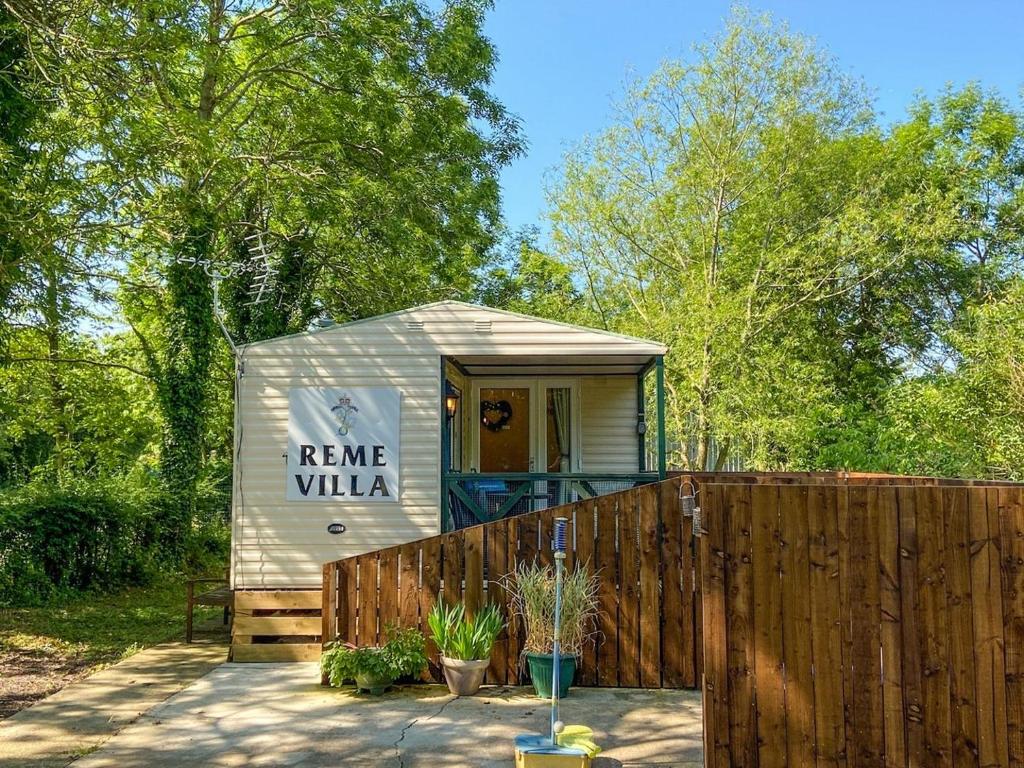 a tiny house in a backyard with a fence at The Reme Villa in Scorton