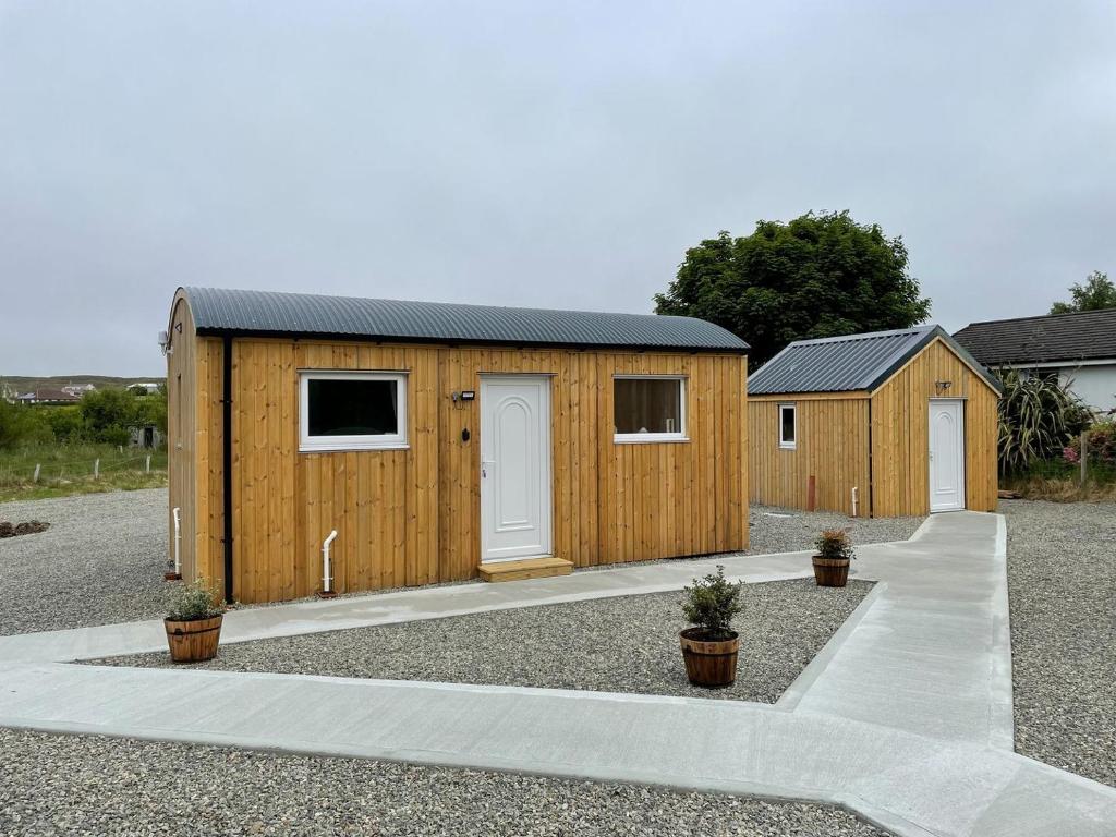 a wooden shed with two doors and two plants at Uist - Uk34049 in Stornoway