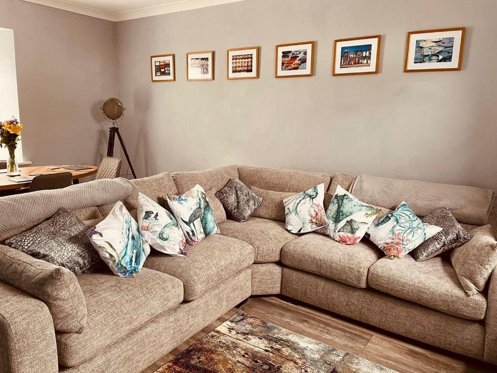 a living room with a brown couch with pillows on it at Ballypride in Girvan