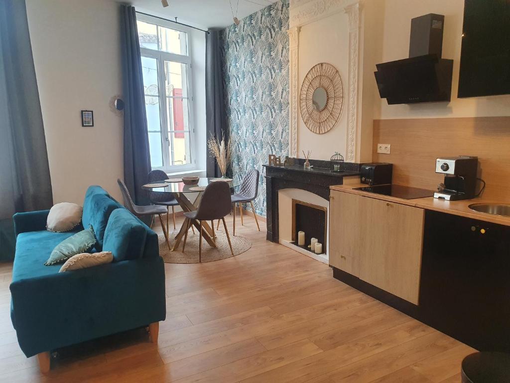 un salon avec un canapé bleu et une cheminée dans l'établissement A l ombre des remparts 3, à Carcassonne