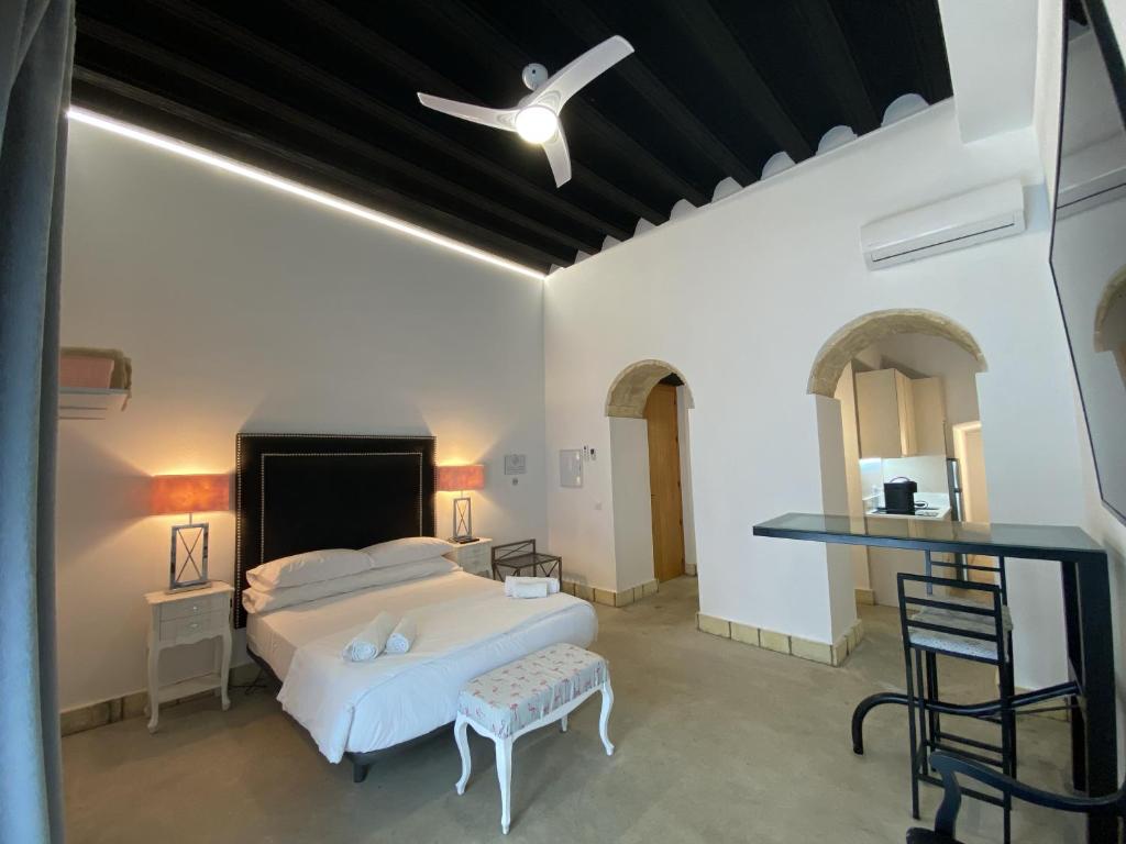 1 dormitorio con cama blanca y techo blanco en CAMASanlúcar en Sanlúcar de Barrameda