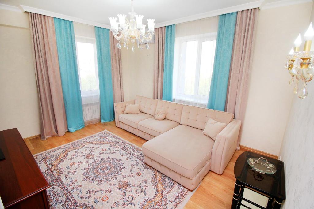 - un salon avec un canapé et un lustre dans l'établissement 2-комнатная квартира в ЖК Гагарин Парк, à Almaty