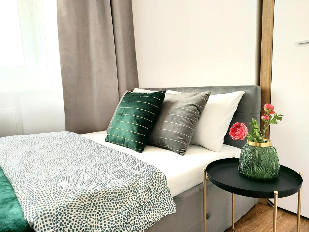 ワルシャワにあるRental Apartments Smolnaのベッド(緑と白の枕、テーブル付)