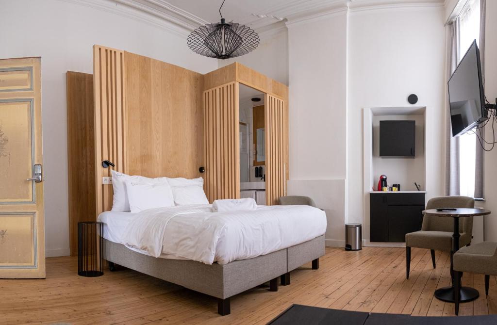 sypialnia z dużym łóżkiem z drewnianym zagłówkiem w obiekcie Heirloom Hotels - The Mansion w Gandawie