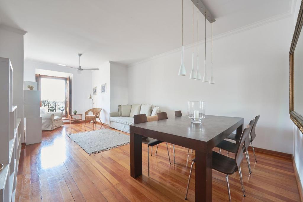 a dining room and living room with a table and chairs at Charming Apartment in Alfama with River View in Lisbon