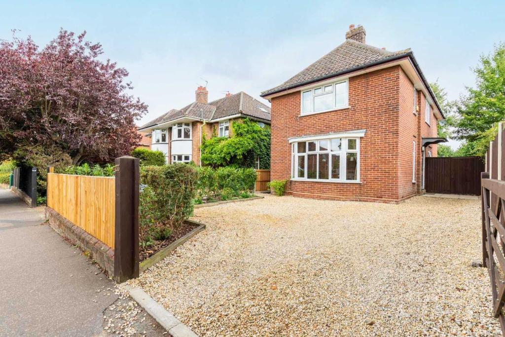 a brick house with a fence and a driveway at St Clements House - Norfolk Holiday Properties in Norwich