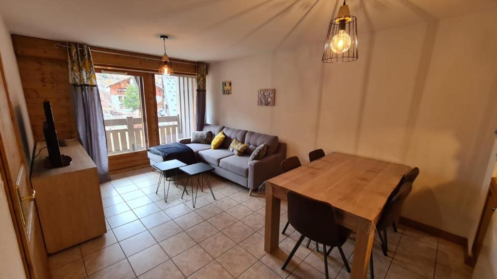 un salon avec une table et un canapé dans l'établissement Apprt 41m2 6 pers avec 2 chambres, 1 coin montage avec garage, à Les Deux Alpes