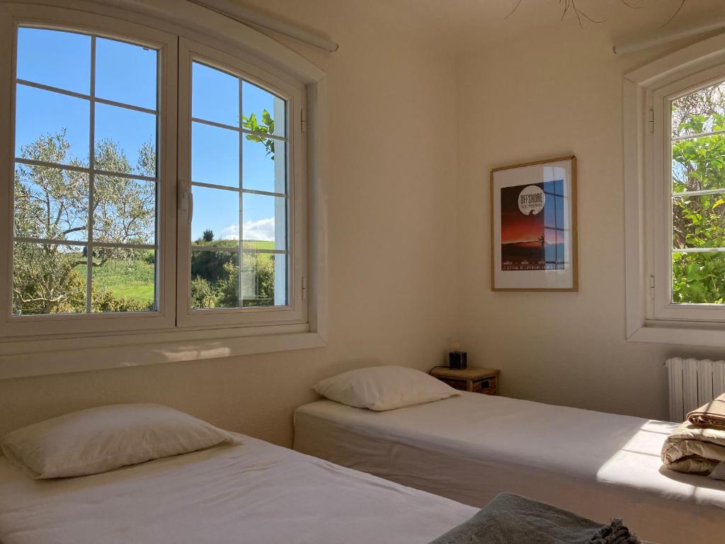 two beds in a room with two windows at Amama Baita in Urrugne