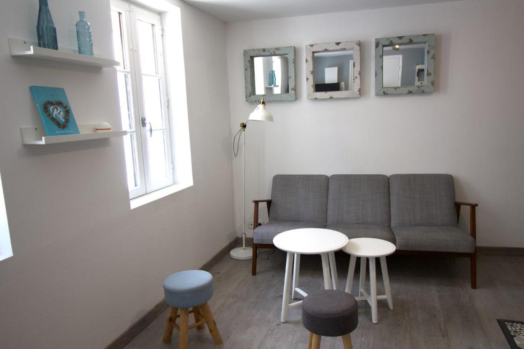 a living room with a couch and two tables and two mirrors at Cosy Apartment In The Center Of La Flotte in La Flotte