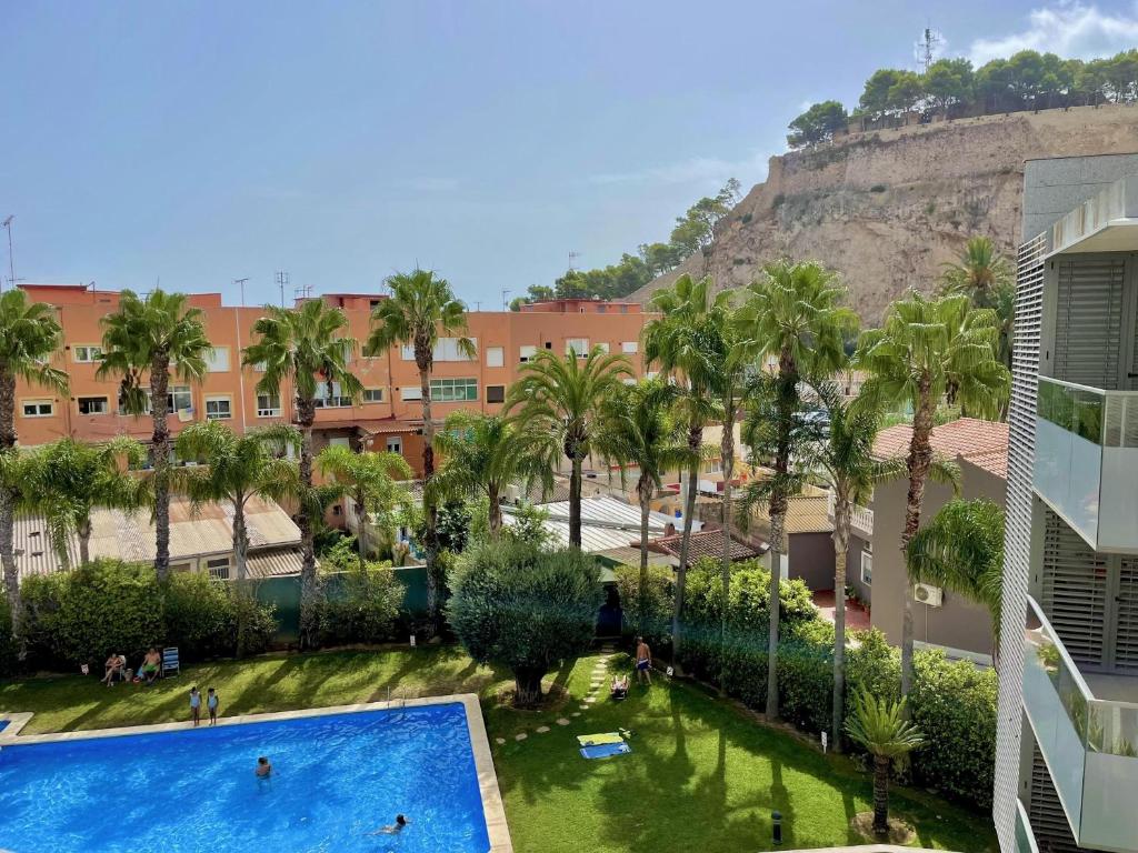 a view of a resort with palm trees and a swimming pool at Marina Raset, 3 dormitorios, centro, by Bookindenia in Denia