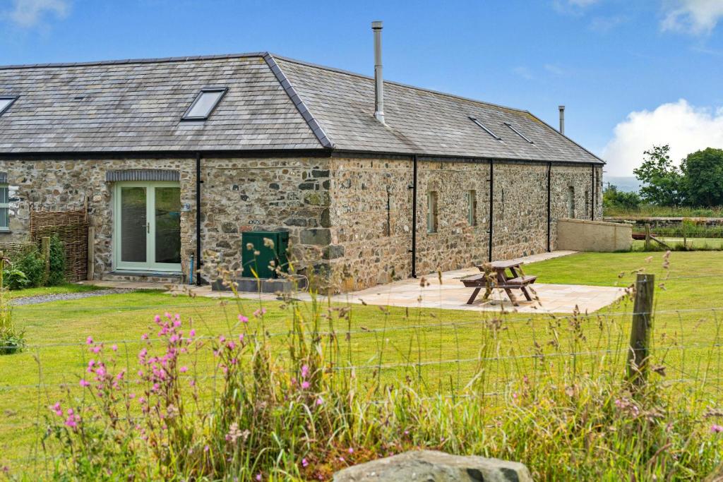 a stone building with a picnic table in front of it at Finest Retreats - Min Yr Awel Barn in Fishguard