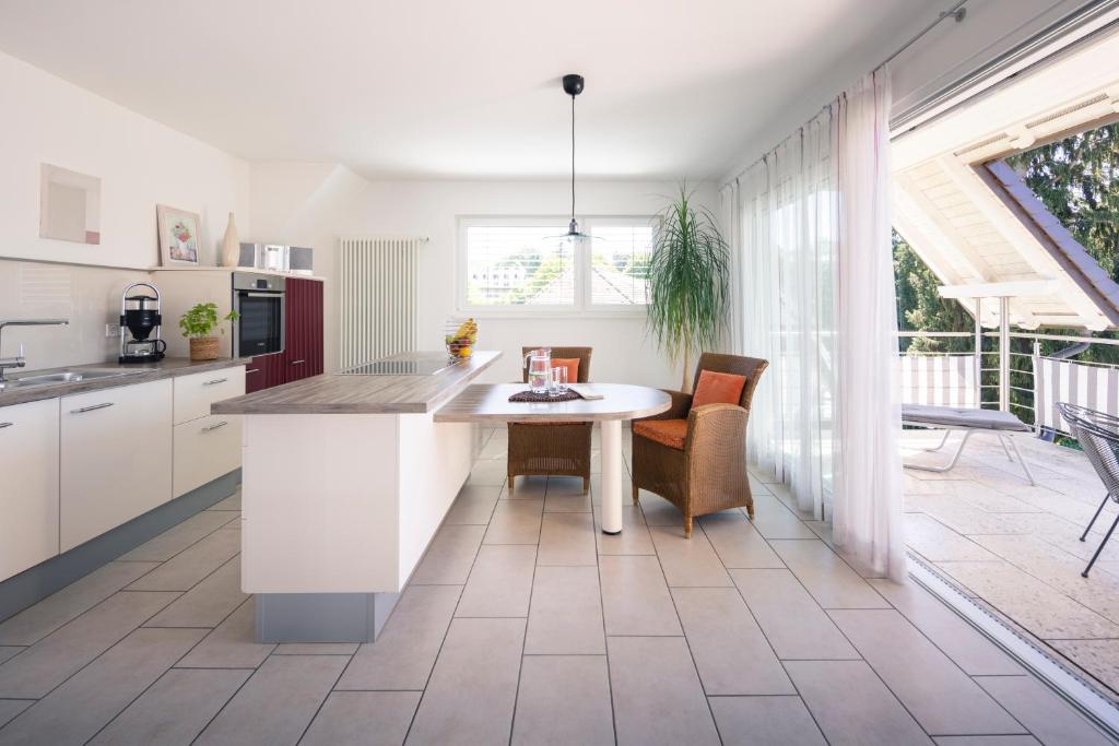 a kitchen with white cabinets and a table and chairs at Kurviertel Wohnung II in Überlingen