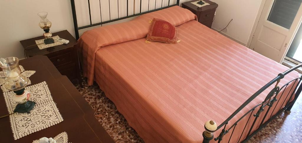 1 dormitorio con 1 cama con edredón rojo en Casa Vacanza a Punta Secca, en Punta Secca