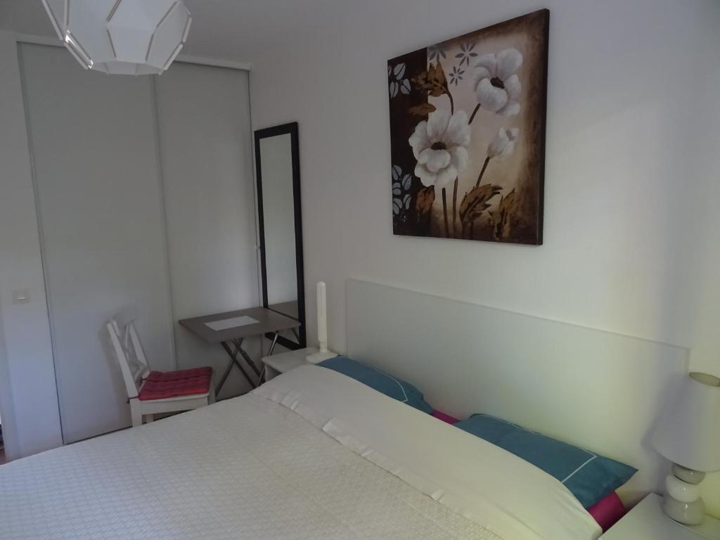 ein Schlafzimmer mit einem Bett und einem Bild an der Wand in der Unterkunft Le Hameau in Mutzig