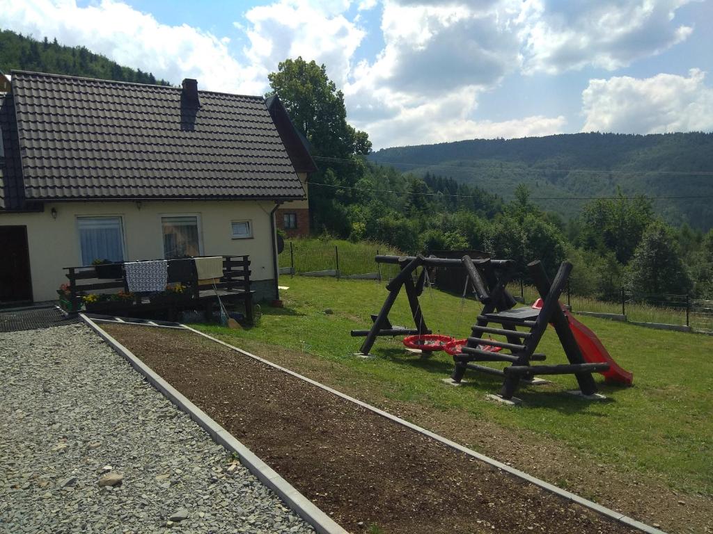 a yard with two playground equipment in front of a house at Babia Chata in Zawoja