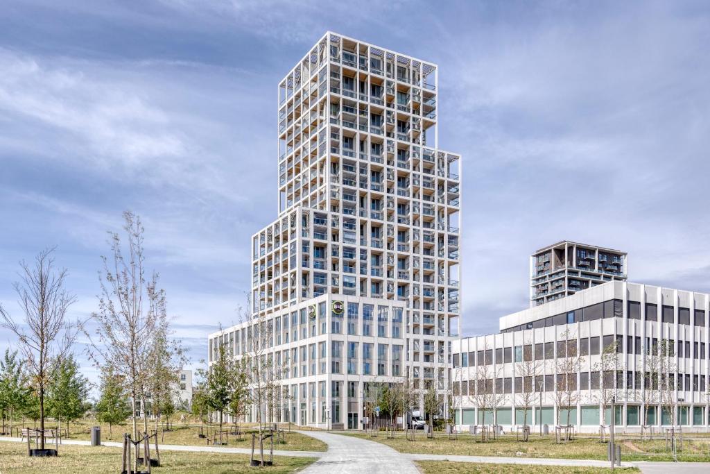 een weergave van een hoog gebouw in een park bij B&B HOTEL Antwerpen Zuid in Antwerpen