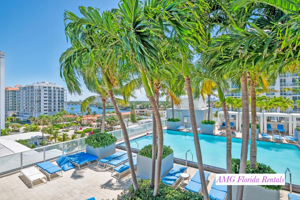 フォート・ローダーデールにあるLuxury 1 BR at Fort Lauderdaleのヤシの木とラウンジチェアのあるプールの眺め
