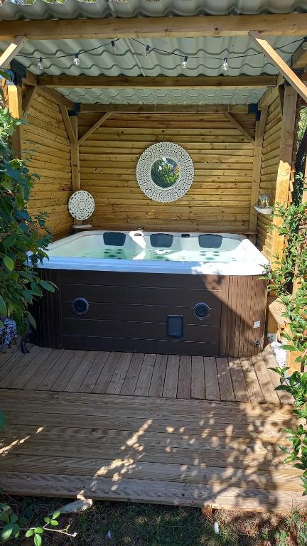 a hot tub sitting on a wooden deck at Arche de Lanoë jacuzzi in Labastide-Saint-Pierre