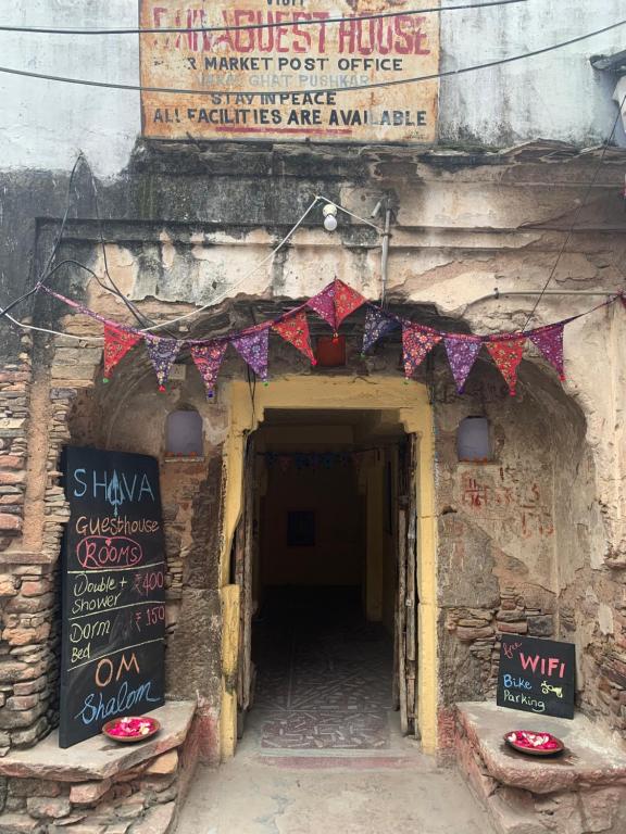 einen Eingang zu einem Gebäude mit Schildern darauf in der Unterkunft Shiva Guest House in Pushkar