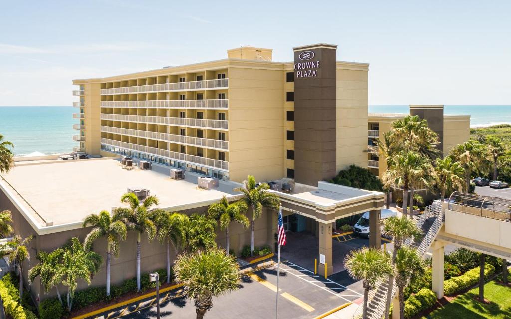 an aerial view of a hotel with palm trees and the ocean at Crowne Plaza Melbourne-Oceanfront, an IHG Hotel in Melbourne