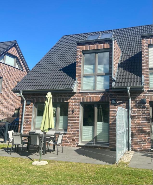 a house with a table and an umbrella in front of it at 1360- Annina 1 in Dahme