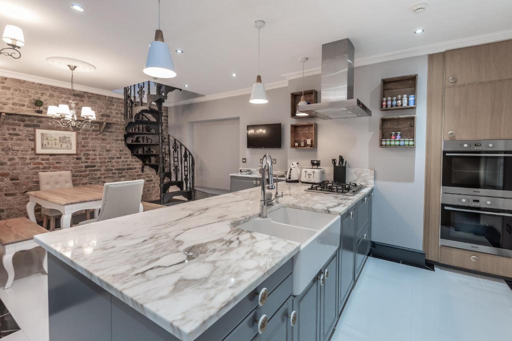 a kitchen with a large marble counter top at The London House - Entire Villa in London