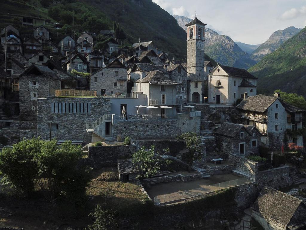 een oud dorp met een klokkentoren in de bergen bij Corippo Albergo Diffuso 