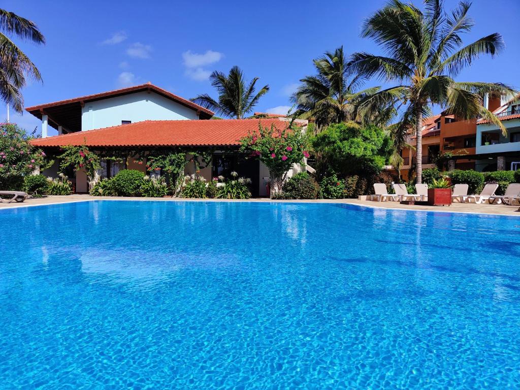 a large blue swimming pool in front of a house at Albis Harena - Porto Antigo 2 in Santa Maria