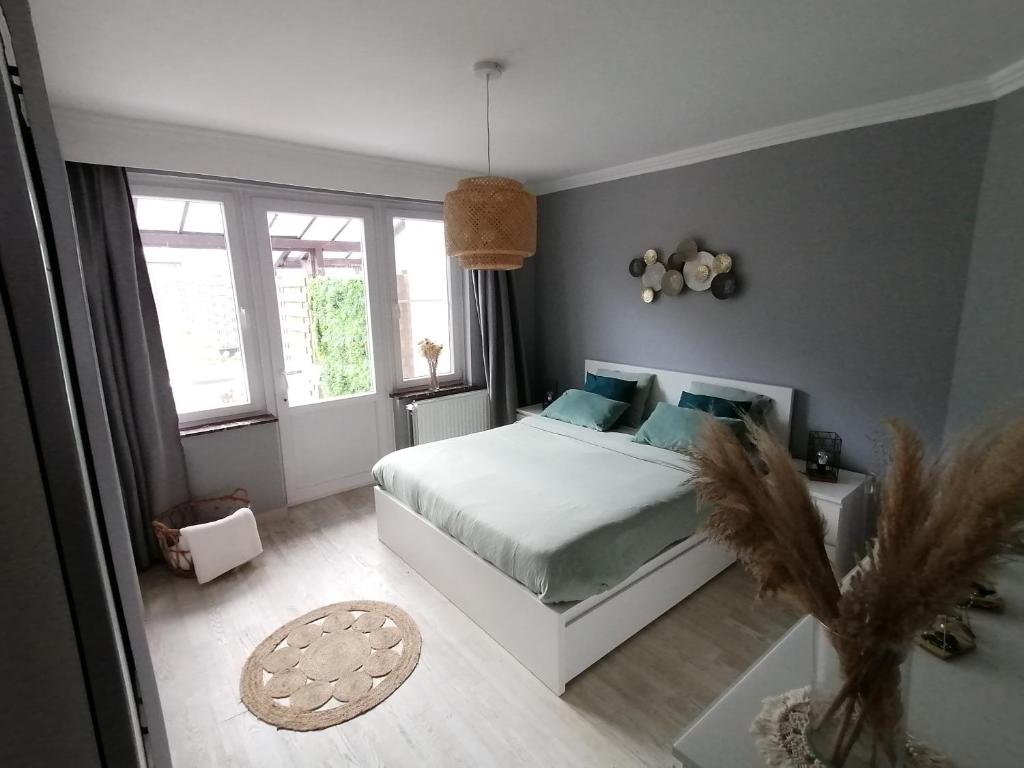 1 dormitorio con cama blanca y almohadas azules en La casa di Deborah en Namur