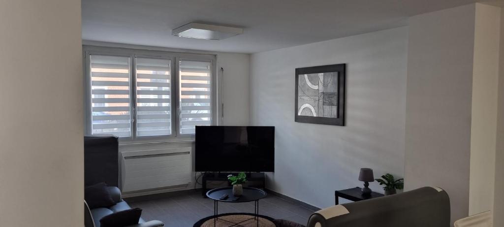 uma sala de estar com uma televisão de ecrã plano e uma janela em maison meublée 6 personnes em Cappelle-la-Grande
