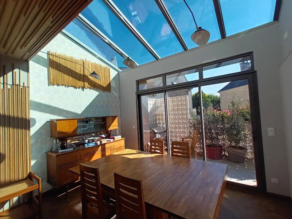 une salle à manger avec une table et une grande fenêtre dans l'établissement Maison 1949, à Saint-Sauveur-le-Vicomte