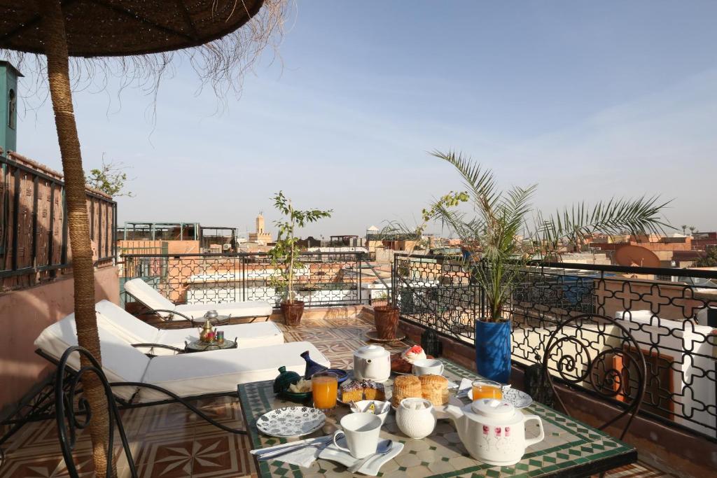 una mesa con comida en la parte superior de un balcón en Riad Maissoun, en Marrakech