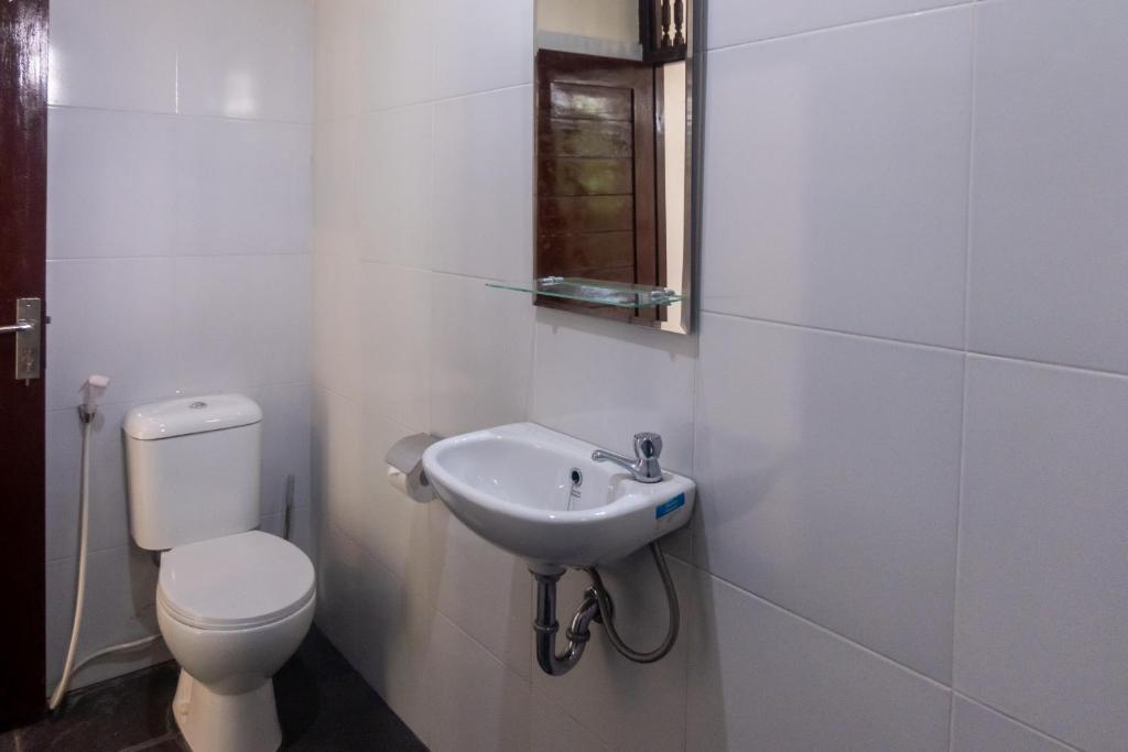 La salle de bains blanche est pourvue de toilettes et d'un lavabo. dans l'établissement Sandora Homestay with Private Pool by Supala, à Ubud