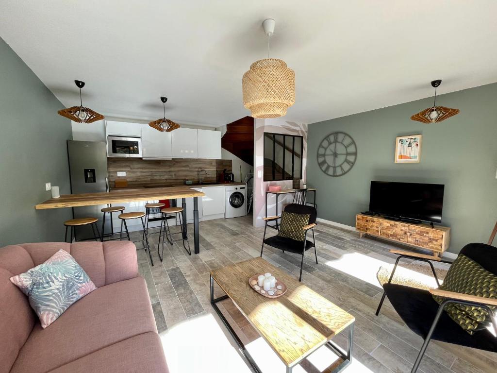 ein Wohnzimmer mit einem Sofa und einem Tisch in der Unterkunft Maison chaleureuse sous les pins in Seignosse