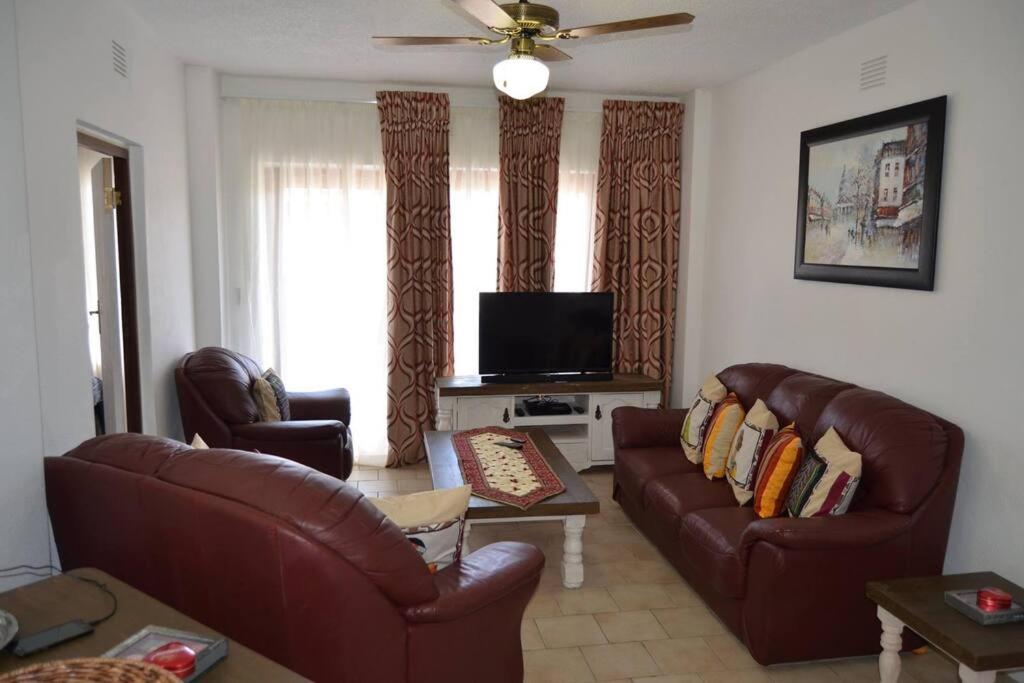 a living room with two leather couches and a television at 2Bed 2Bath Vacation home with pool close to beach in Margate