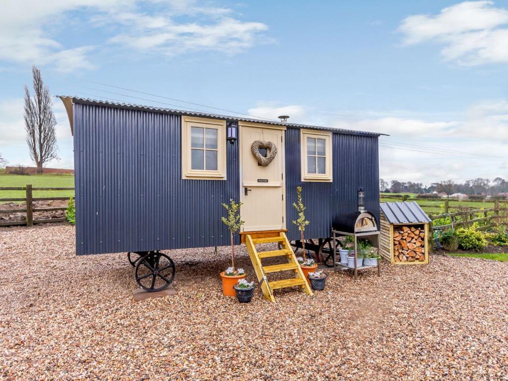 a tiny house sitting on top of a gravel yard at The Lambing Shed in Ryhill