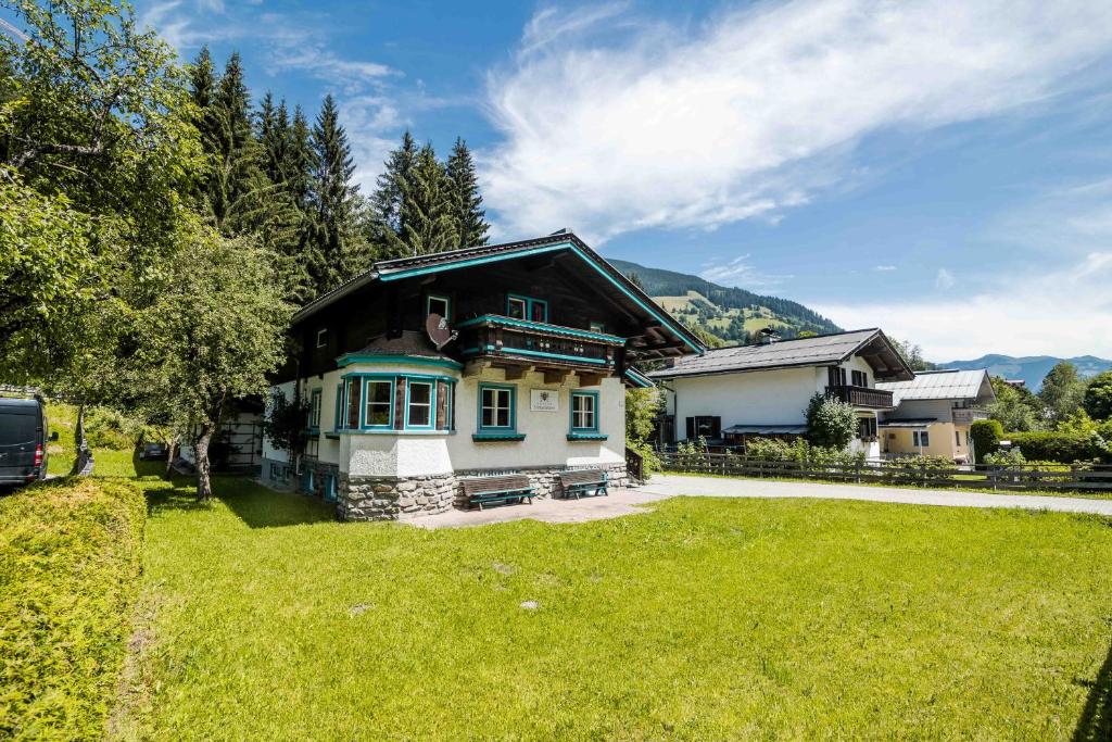 ein Haus mit grünem Rasen davor in der Unterkunft Chalet 3 Musketiers in Viehhofen