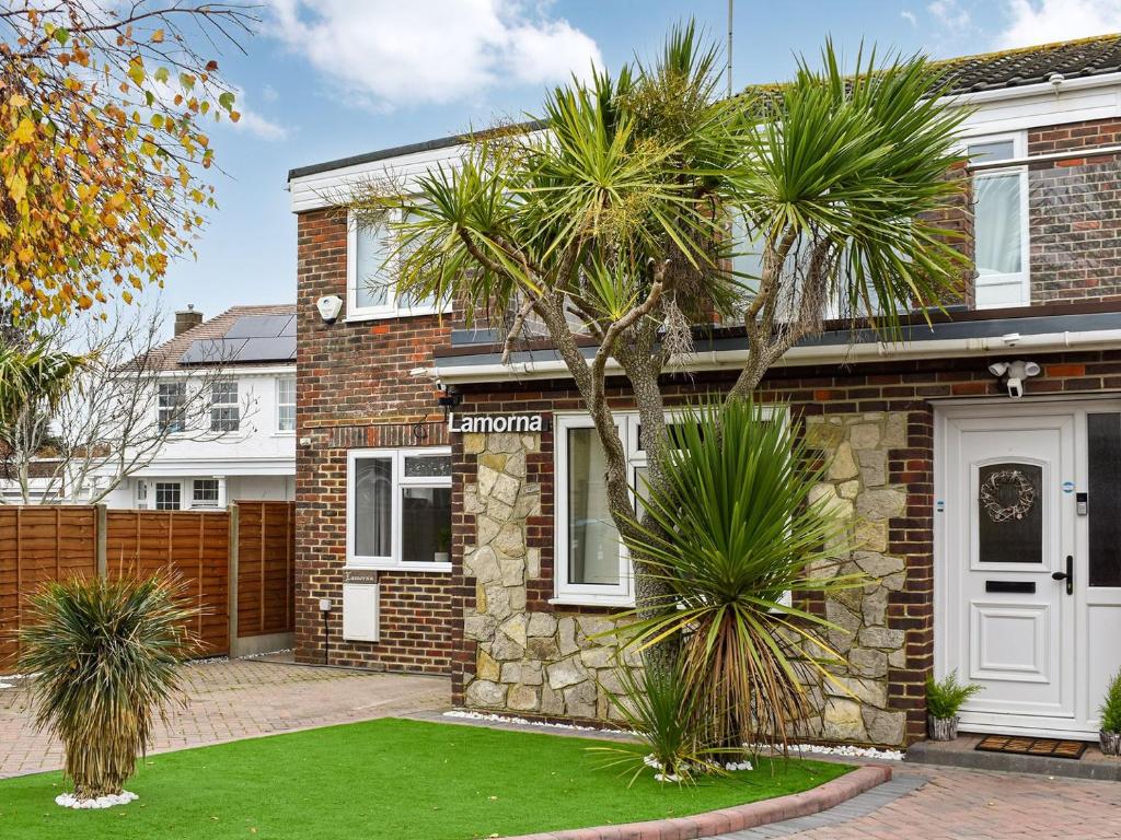 a brick house with palm trees in front of it at Lamorna in Littlehampton