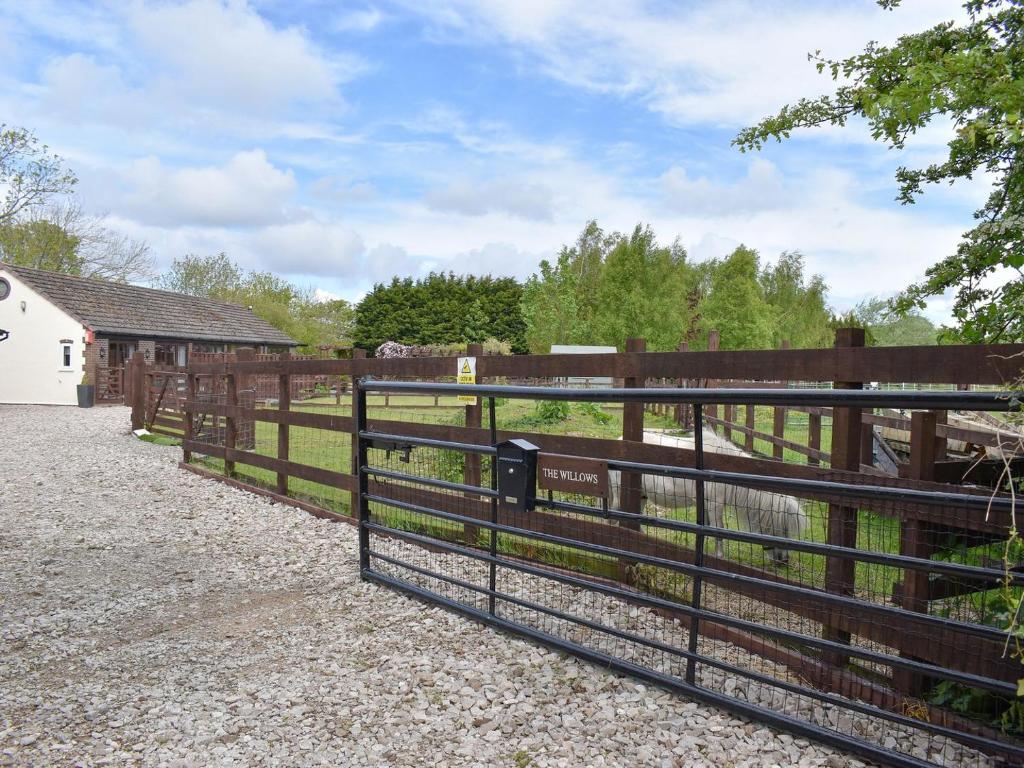 a fence in front of a pasture with a barn at The Willows in Hambleton