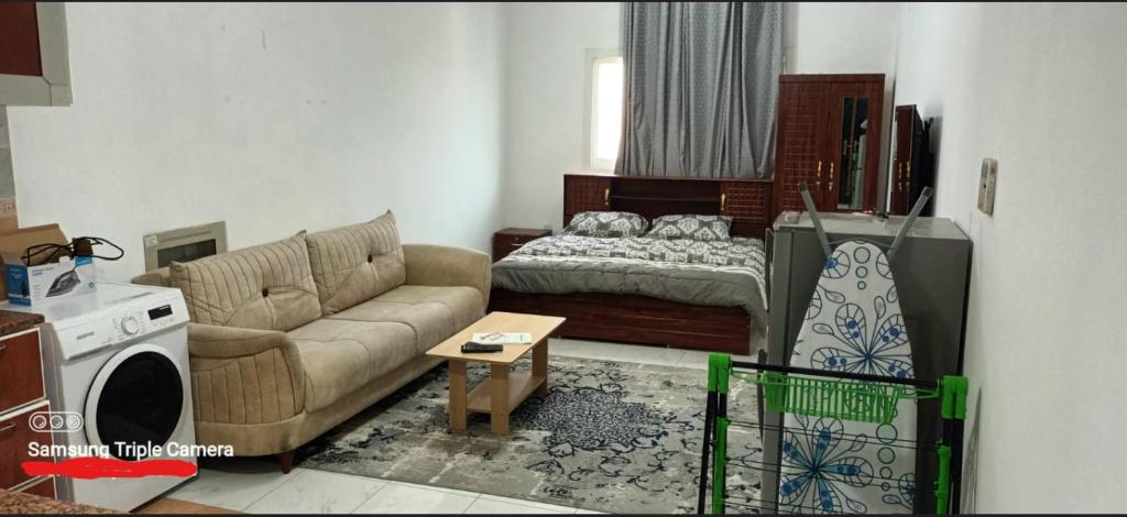 un soggiorno con divano e letto di Apartment in Ajman,Studio flat ad Ajman