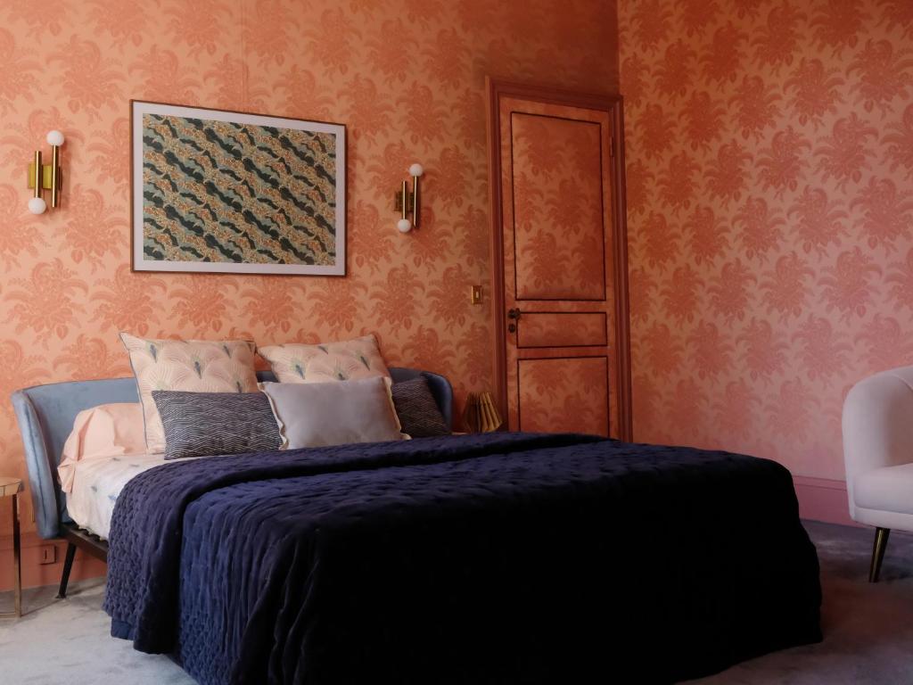 ein Schlafzimmer mit einem Bett und einem Bild an der Wand in der Unterkunft Mille et une feuilles in Saint-Martin-lez-Tatinghem