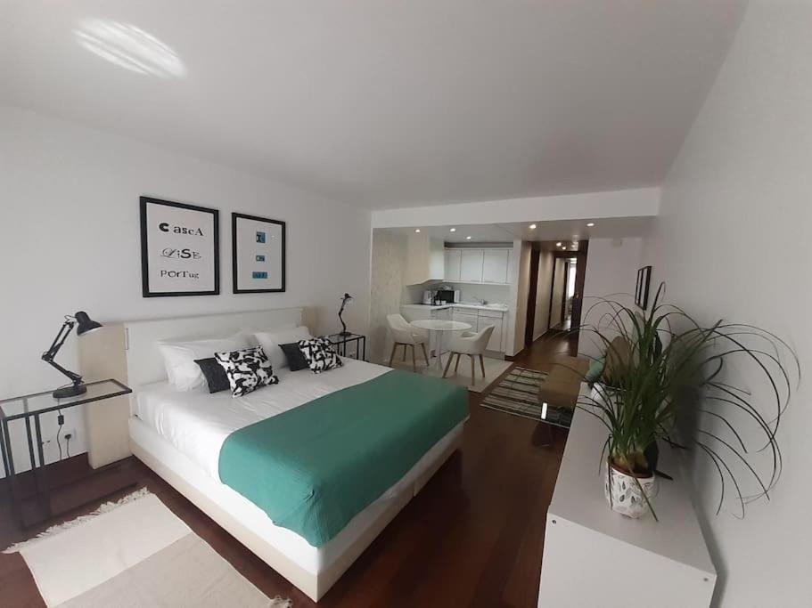 a bedroom with a large bed and a living room at Health Village Apartments in Cascais