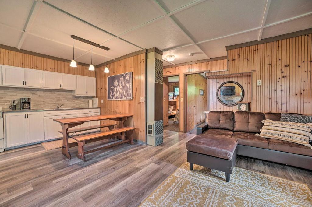 ein Wohnzimmer mit einem Sofa und einem Tisch in der Unterkunft Comfy Burt Lake Abode - On-Site Lake Access! 