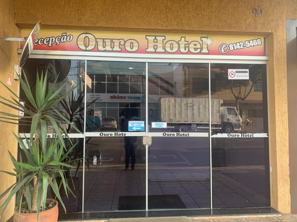 Ouro Hotel في أورينهوس: نافذة أمام متجر تابع لفندق مع شاحنة