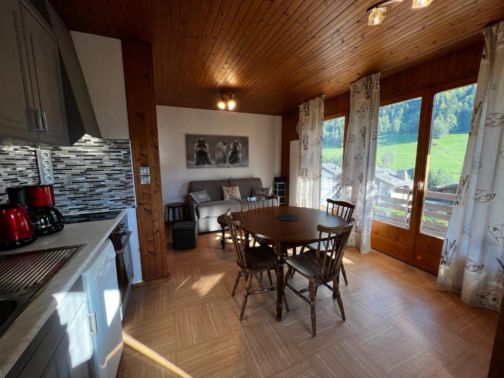 eine Küche und ein Esszimmer mit einem Tisch und Stühlen in der Unterkunft Abricot - Appart dans chalet in La Clusaz