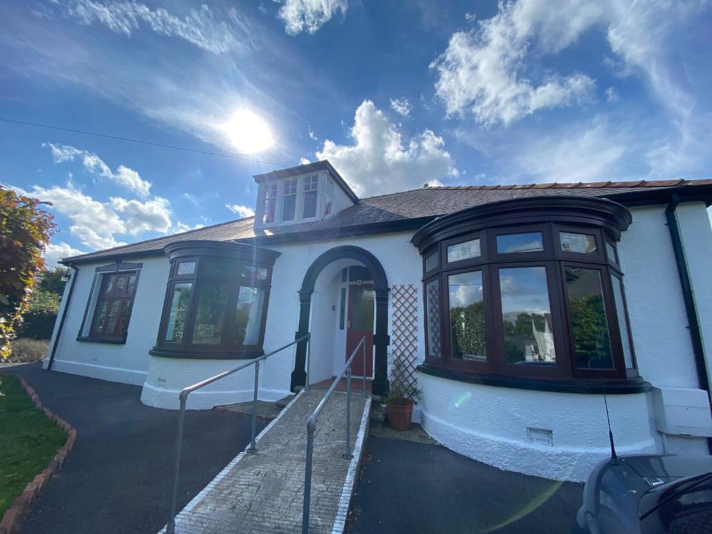 a white house with black windows on a driveway at Newport Kenvor Dinas Cross Easy access bungalow near beaches in Dinas