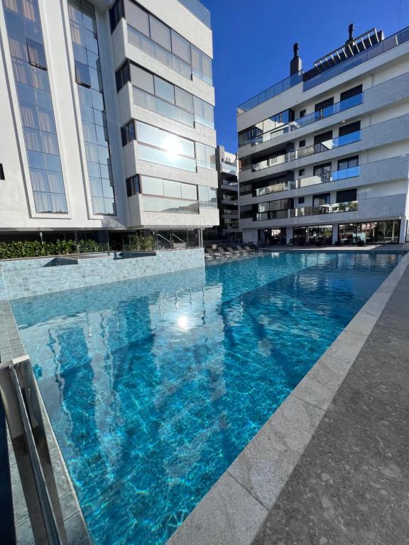 a large swimming pool in front of two buildings at Cobertura Velejar em Condomínio Clube - com Área de Lazer in Governador Celso Ramos