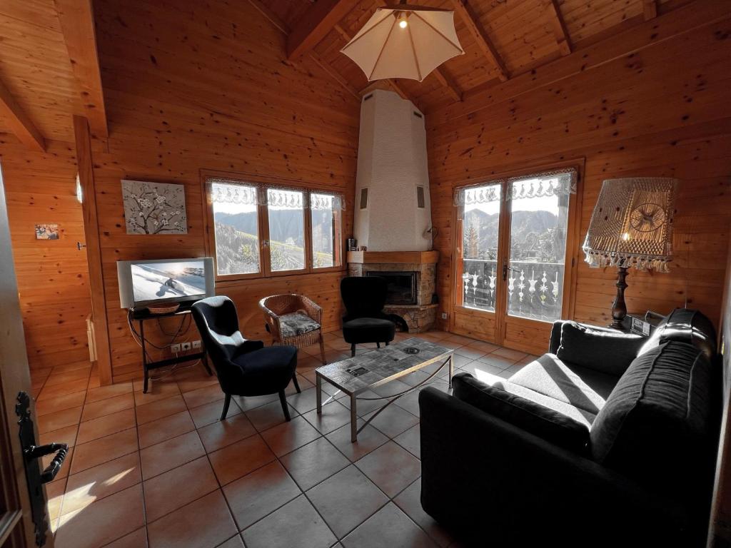 ein Wohnzimmer mit einem Sofa, Stühlen und einem TV in der Unterkunft Murgiers B1 - Chalet mitoyen in La Clusaz