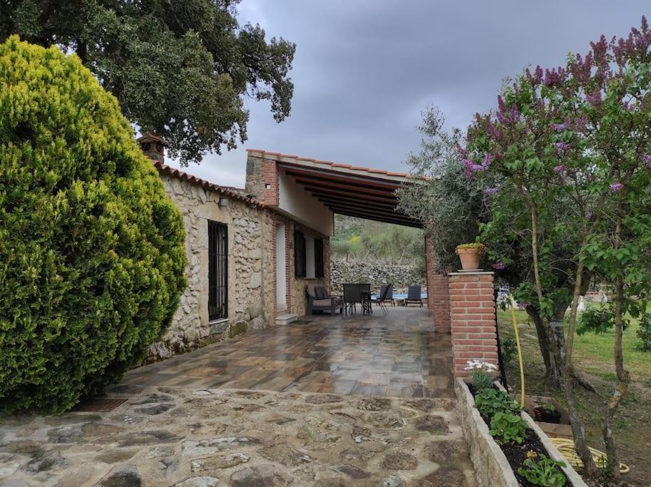 einem externen Blick auf ein Steinhaus mit einer Terrasse in der Unterkunft Casa Rural La Recuera in Montánchez