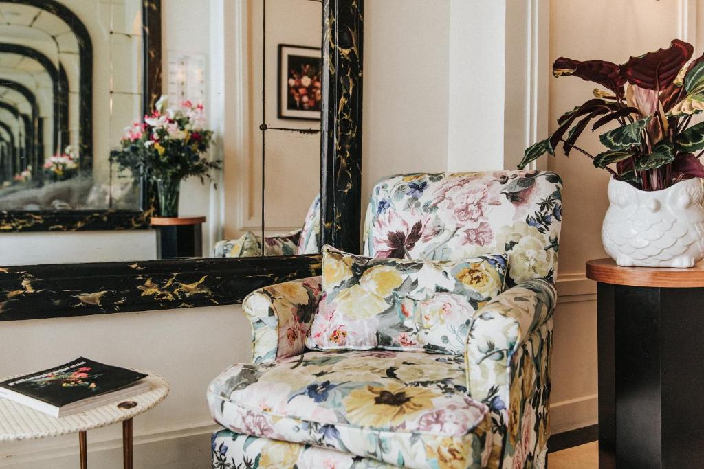 a living room filled with furniture and flowers at Hôtel Bienvenue in Paris